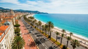 Vue aérienne de Nice, France, montrant la Promenade des Anglais, ses palmiers, la plage de galets et la mer Méditerranée turquoise.